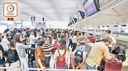 香港快運突然取消多班航機，昨早在登機櫃台前排有大批乘客辦手續。（黃偉邦攝）