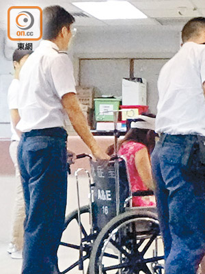 女事主坐在輪椅送抵醫院。（李國健攝）