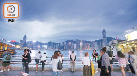 香港<br>昨晚雖掛起三號風球，但不少市民及遊客仍在維港海濱觀夜景。（黃偉邦攝）