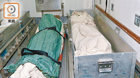 男女死者屍體被舁送殮房。