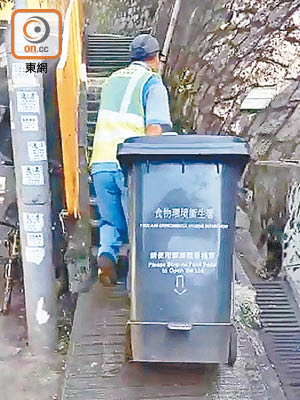清潔工人要在狹窄、陡斜的村路上清理大型垃圾桶，難度大增。（讀者提供）