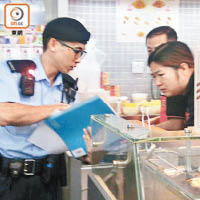 PTU警員向便利店職員進行問卷調查。（容惠玲攝）