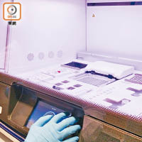 呂偉欣示範將用於放置癌細胞樣本的晶片放入測序儀器。