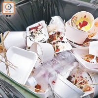 市民將染滿汁液的即棄餐具棄置在垃圾桶內。