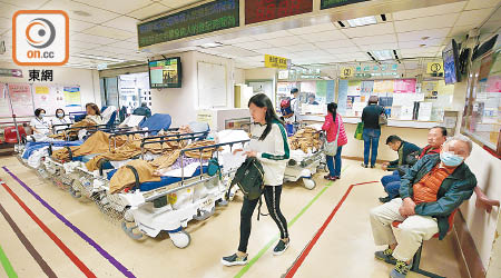 廣華醫院急症室堆滿求診病人和擔架床。（何量鈞攝）