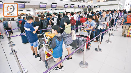 香港快運辦理登機櫃位昨日持續有逾五十人排隊。（黃偉邦攝）