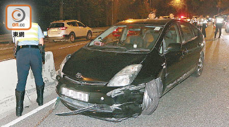 私家車自炒撞壆，警員在場調查。（梁裔楠攝）