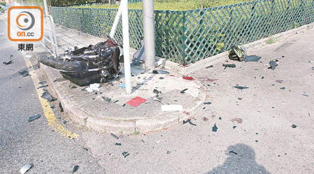 電單車在行人路上翻側，旁邊遺下鐵騎士甩脫的頭盔。（曾紹良攝）