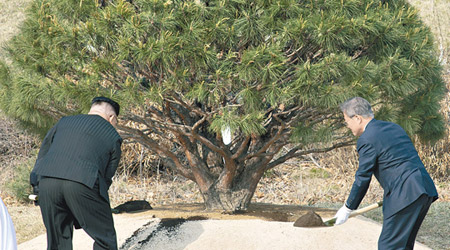 文金二人拿鐵剷舀來自南北韓的泥土，寓意南北和解。