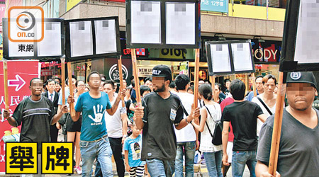 「南亞兵團」被安排在鬧市舉牌遊行，藉抹黑目標人物以達到不法目的。