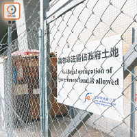 圍封鐵絲網上掛有「請勿非法霸佔政府土地」警告牌。（梁裔楠攝）