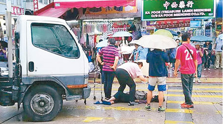 熱心途人撐傘擋雨。（互聯網圖片）