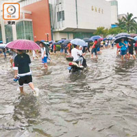 內地暴雨造成路面水浸，考生要涉水赴考。