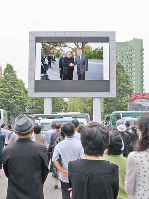 平壤民眾觀看金正恩訪星報道。（美聯社圖片）