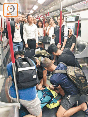 四名在場乘客將涉案背包男按在地上。（讀者提供）