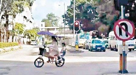 網上片段顯示婦人駕駛電動單車載着女童，不依交通燈號行駛。（互聯網圖片）