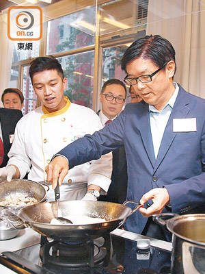 胡炎松（右）喺烹飪嘅活動上顯身手，示範整反沙芋。（溫國佳攝）
