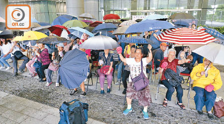 參與大辯論的長者及市民撐傘，象徵為長者及殘疾人士遮風擋雨。（黃偉邦攝）