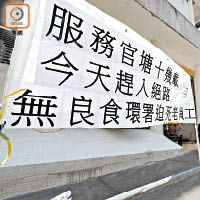 現場有「迫死老員工」標語，不滿食環署要求外判公司解僱年長工友。