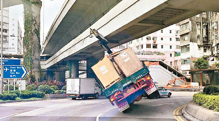 吊臂車卡在天橋橋底，右轆離地，車身向左傾側。（互聯網圖片）