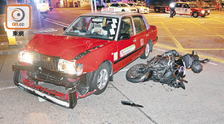 的士與電單車相撞後，車頭嚴重損毀。（胡德威攝）