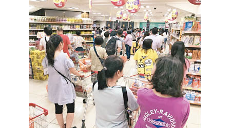 超市擠滿人潮，市民要排長龍付款。（互聯網圖片）