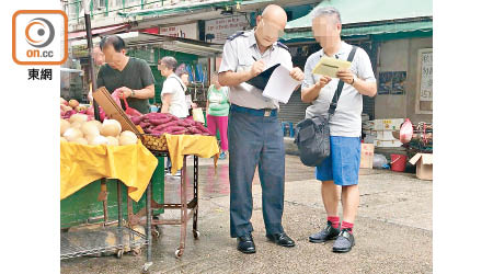 新填地街<br>10:04AM<br>有檔主向食環署人員展示牌照。