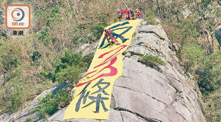 消防員游繩而下拆除直幡。（陳賜慧攝）