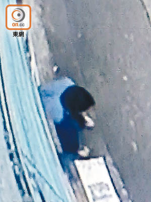 賊人坐在地上反手撬開玻璃門鎖頭。