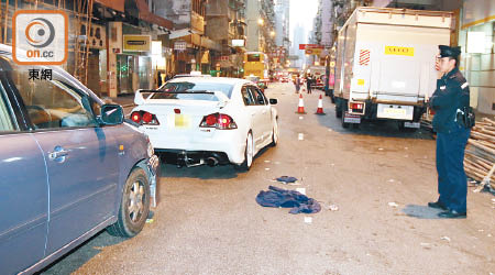 傷者駕駛之白色跑車被撞尾停於路旁，警員在現場調查。