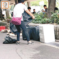 即場拆驗<br>一名女子負責收貨後即拆走黑色膠袋，放置花槽一旁。