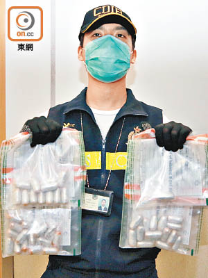 海關展示疑犯排出的毒品膠囊。(文健雄攝)