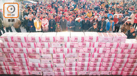 四川涼山州村委會將一千三百多萬元人民幣砌成「錢牆」分發。