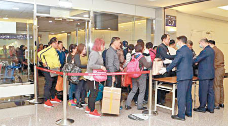 來自大陸、香港、澳門班機的旅客，排隊接受手提行李檢查。（中時電子報圖片）