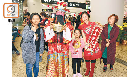 港鐵昨於西九龍站出動「財神」向乘客派糖，為市民送上新年祝福。（何天成攝）