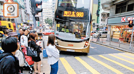 菲林明道<br>有女士站得較貼近車路，與巴士轉彎時只距離十多厘米，險象環生。