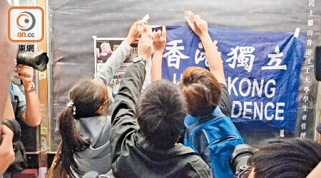 何俊謙（黑衣者）於民主牆貼上寫有「香港獨立」的旗幟。