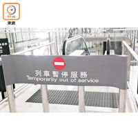 往月台的扶手電梯前貼出列車暫停服務告示。（讀者提供）
