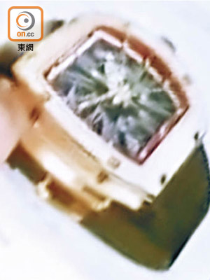 東主展示被偷去同款鑽錶相片。（梁志雄攝）