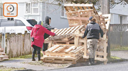 不少居民從送到收集站的卡板堆中揀選木材，作不同用途。