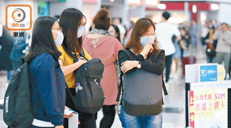 機場的訪客紛紛戴上口罩預防麻疹。（何量鈞攝）