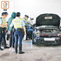 警方將兩名疑犯押往私家車搜查。（趙瑞麟攝）