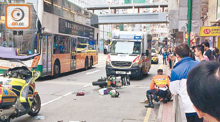 電單車翻側，救援人員了解傷者情況。（讀者提供）