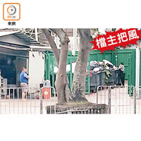 疑是士多男檔主（左）不時在站外負責把風，女工執到食材後旋即運入士多。