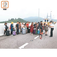 拖行李篋的乘客在橋中等候安排。