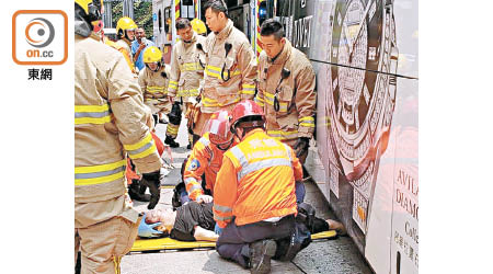 消防員在車底救出傷者。（讀者提供）