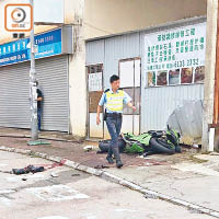 電單車橫亘行人路，警員在場調查。（讀者提供）