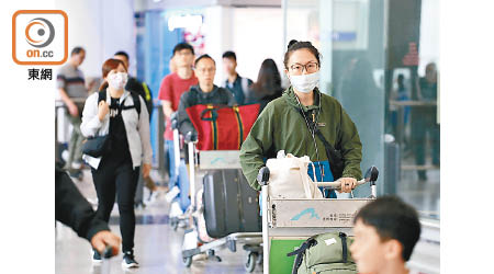 不少返港旅客有戴上口罩防麻疹。（羅錦鴻攝）