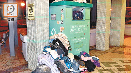 舊衣物回收箱被塞爆，部分衣物被放在箱旁。（梁頴福攝）