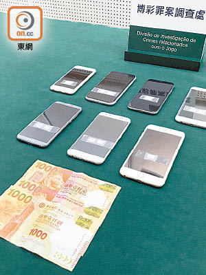 司警展示檢獲的手機、現金等證物。